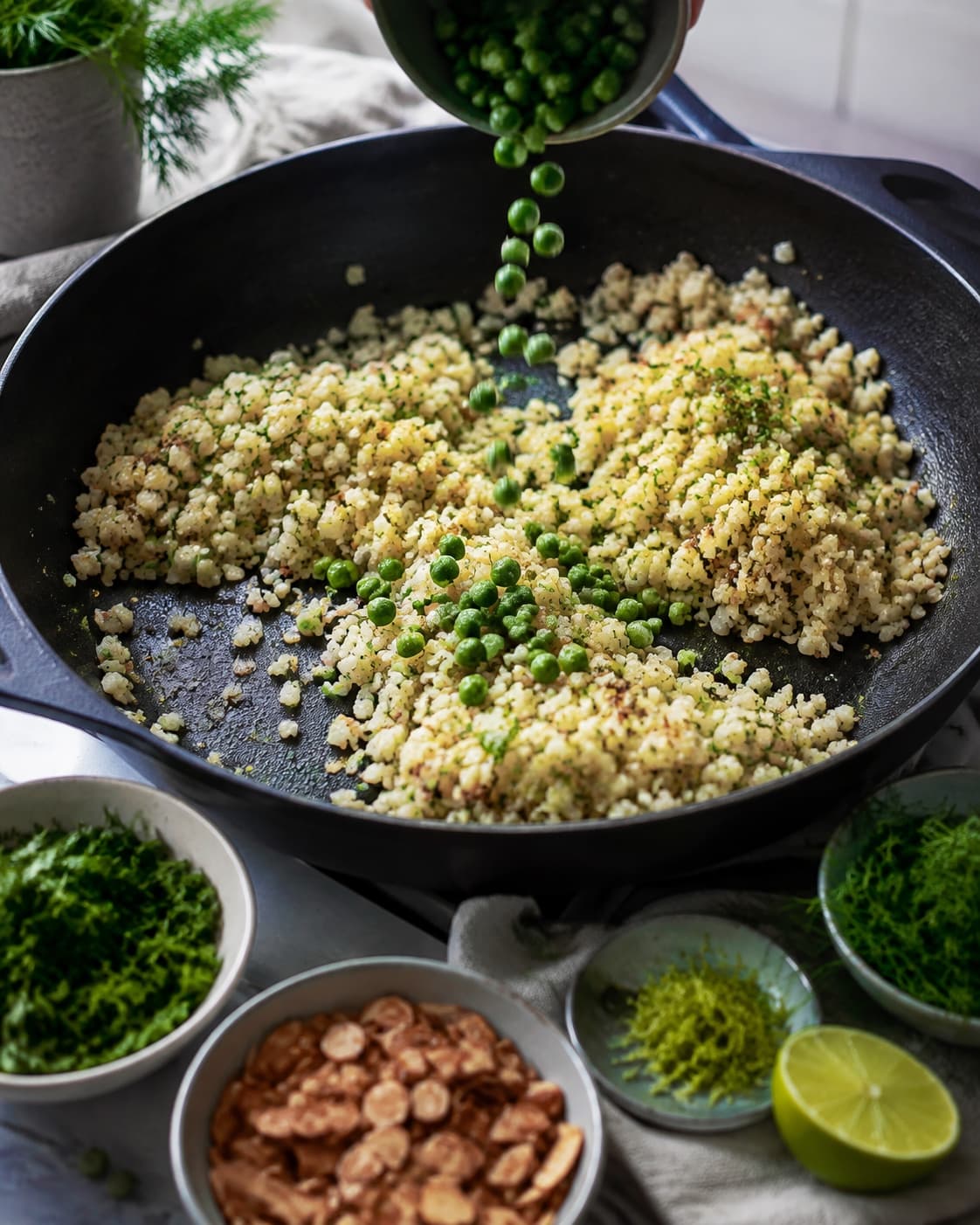 Stegte blomkålsris vendes med ærter, lime, urter og mandler