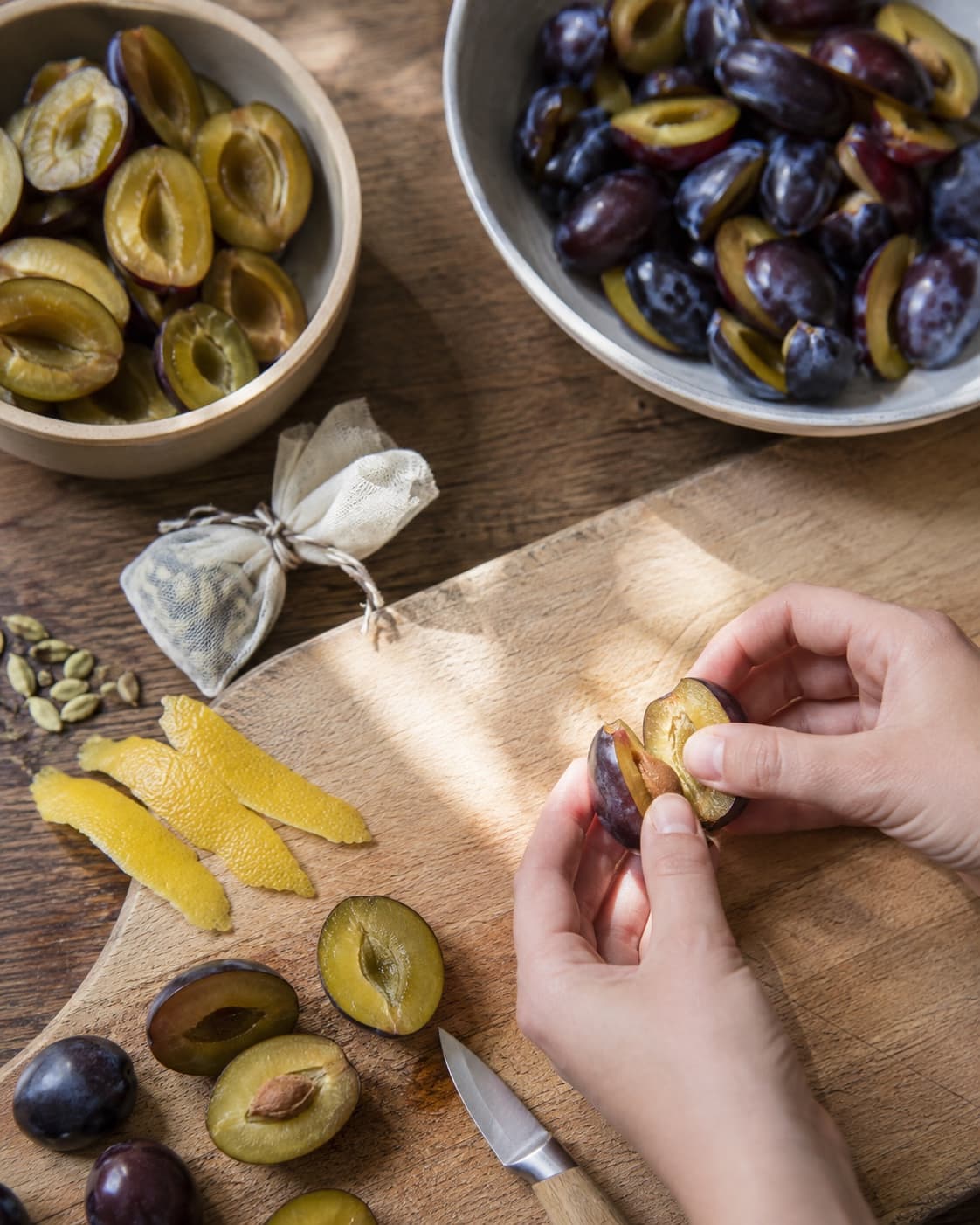 Udstenede blommer deles mens kardemomme og citronskal pakkes