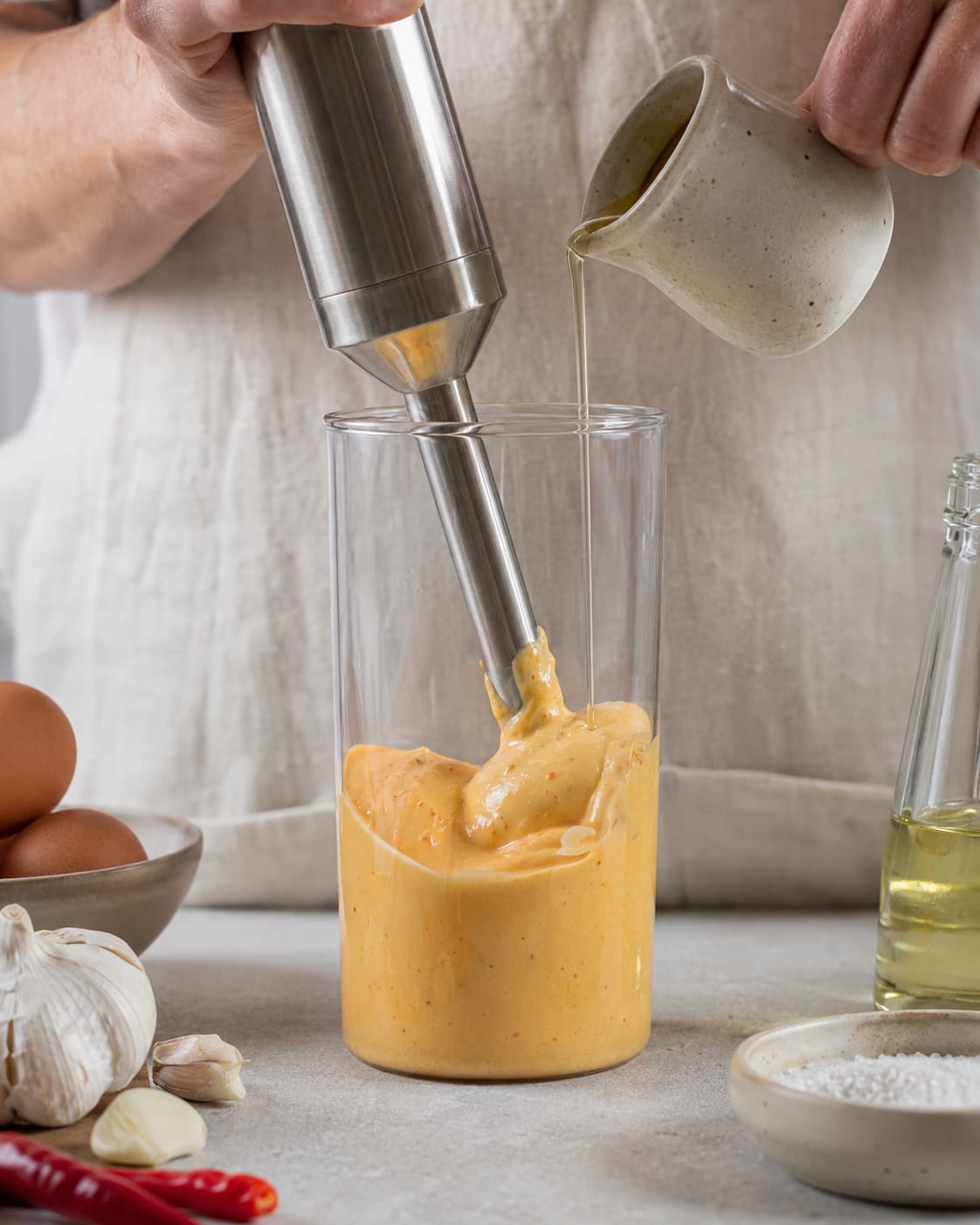 Neutral olie blendes langsomt i chilibasen til en tyk blank emulsion
