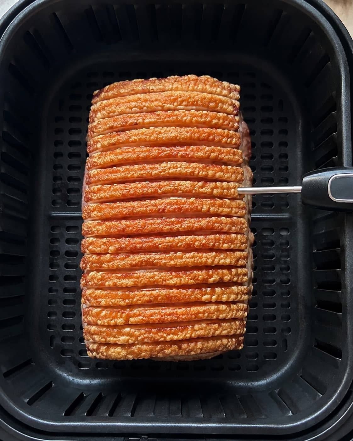 Flæskesteg med ensartede sprøde sværbaner temperaturmåles fra siden i airfryeren