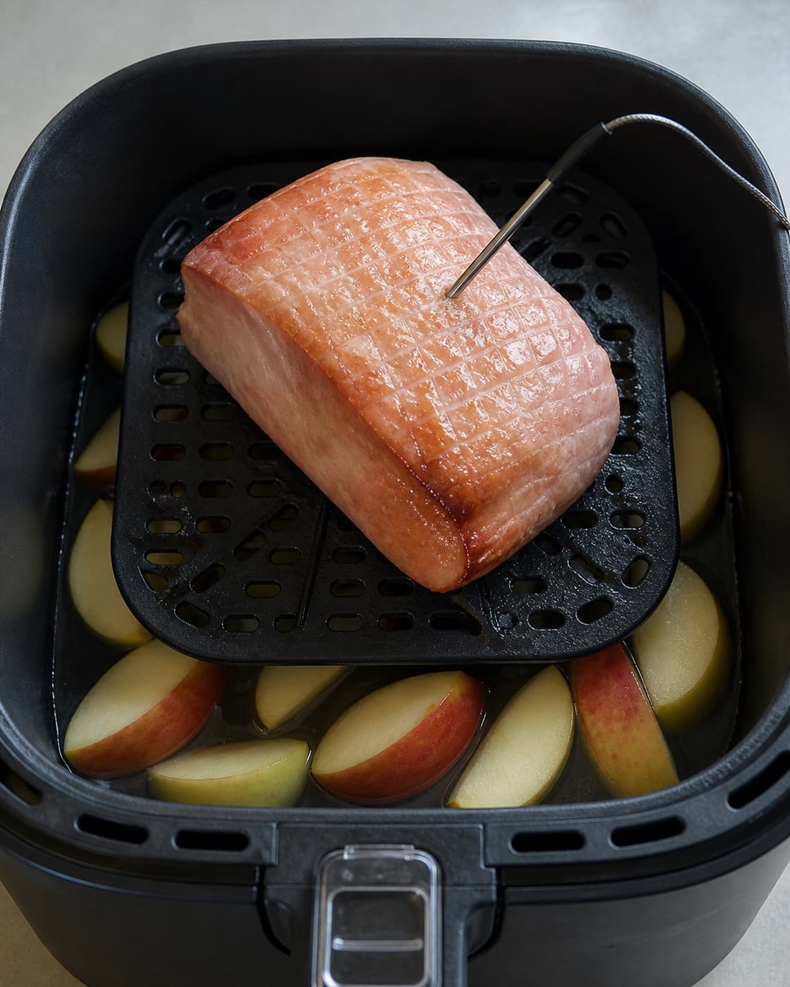 Hamburgerryg tilberedes i airfryer over æble og vand med termometer i centrum