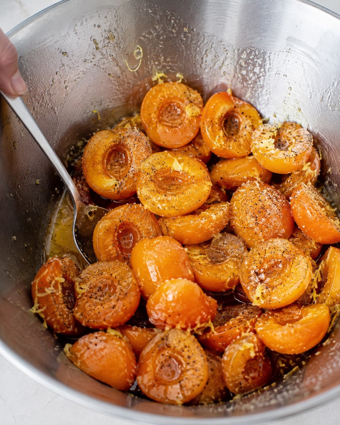 Udstenede abrikoser trækker med sukker, citron og vanilje, mens orange saft samler sig