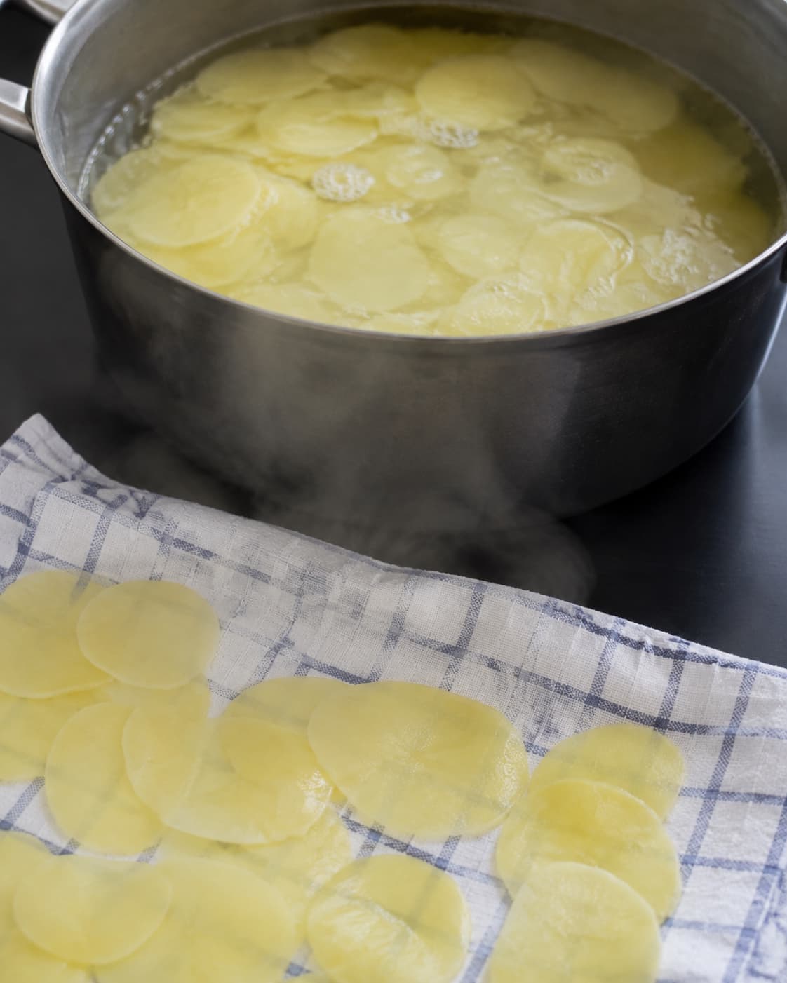 Tynde ens kartoffelskiver blancheres og damper tørre på et klæde