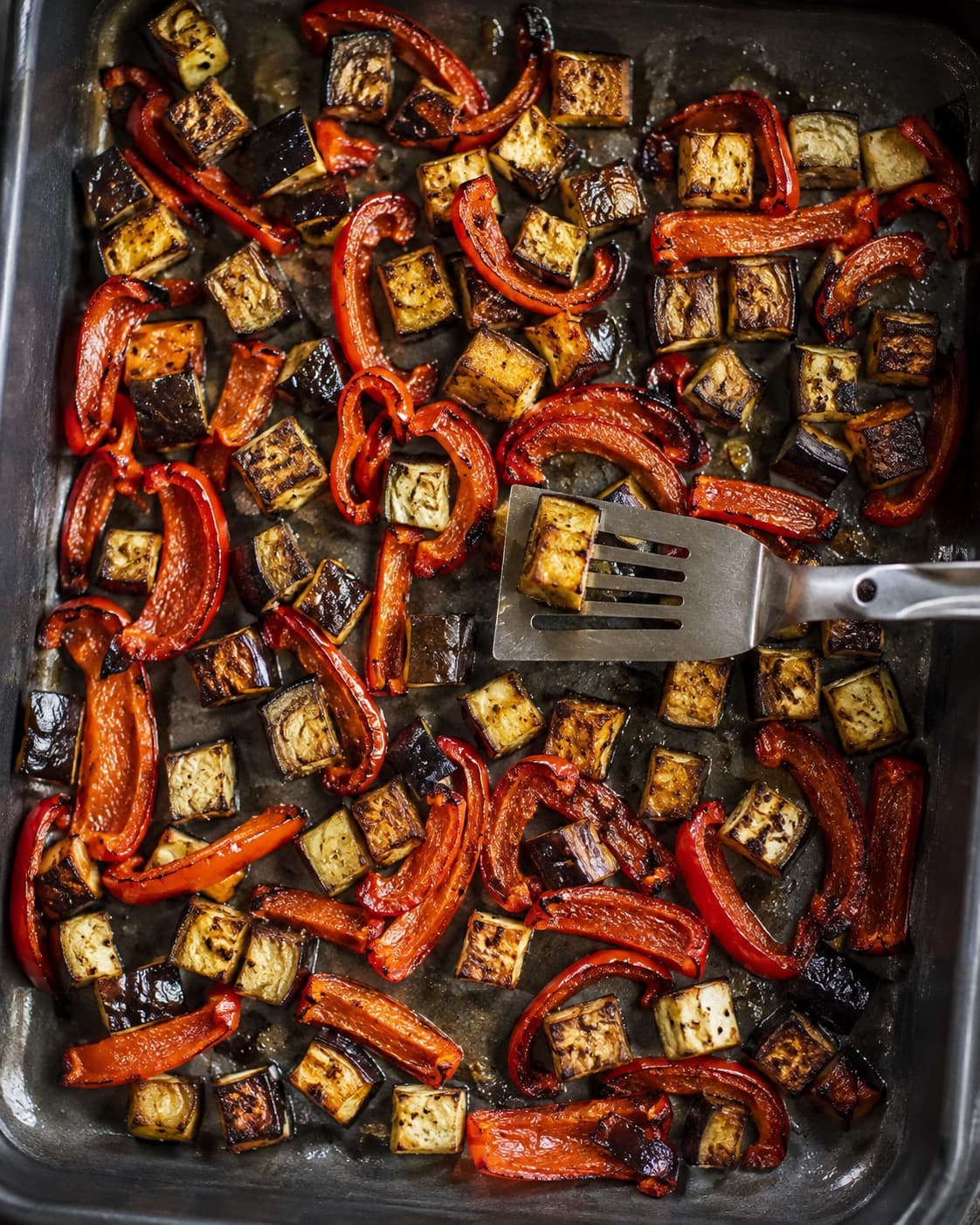 Auberginetern og røde peberstrimler ristes gyldne i ét lag