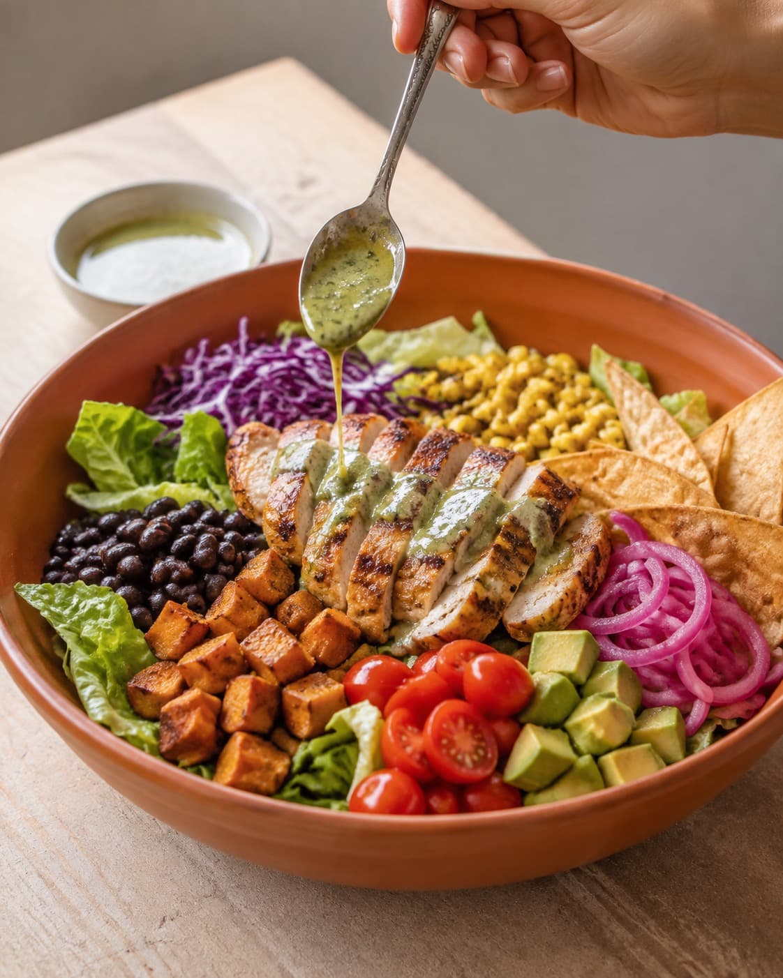 Mexicansk salat samles i zoner med kylling, bønner, sød kartoffel, majs, grønt og tortillaknas