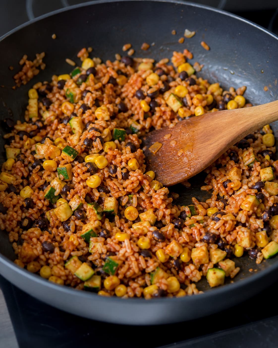 Ris, sorte bønner, majs og squash vendes med ristet tomatpuré i panden