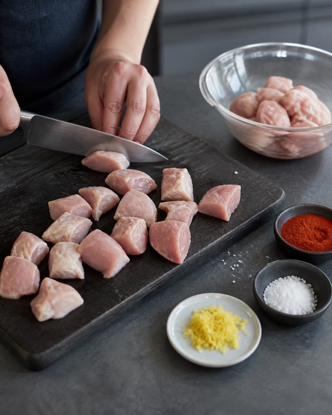 Kyllingelår skæres på separat bræt i ens nuggetstykker med paprika og citronskal