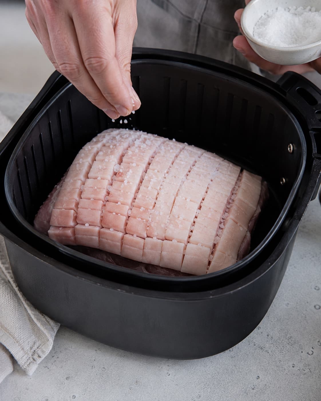 Saltet ribbensteg tilberedes vandret i airfryer over lav bundvæske med æble og laurbær