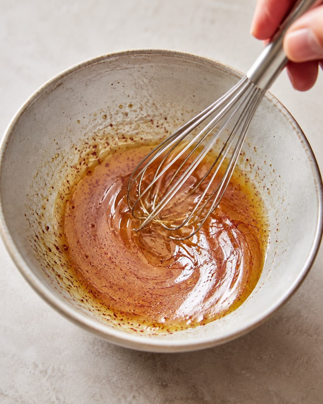 Lime, sumak og honning piskes med olivenolie til en blank rosa dressing