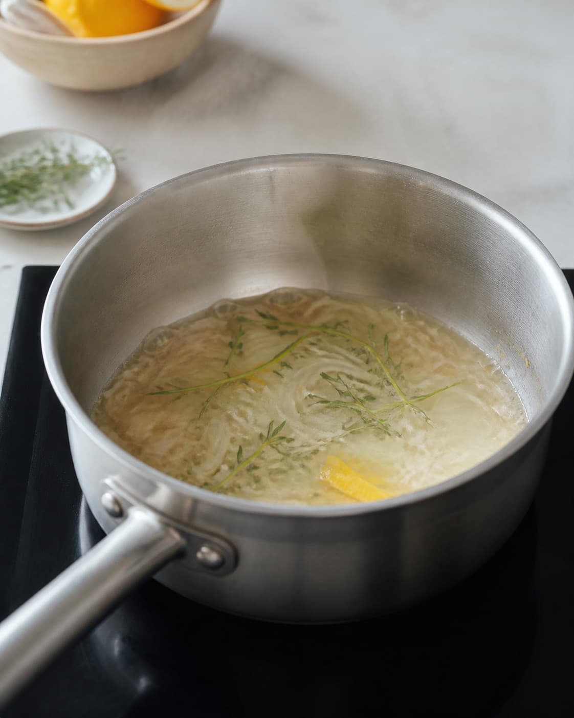 Fiskefond med skalotteløg, citronskal og estragon reducerer ved rolig simren