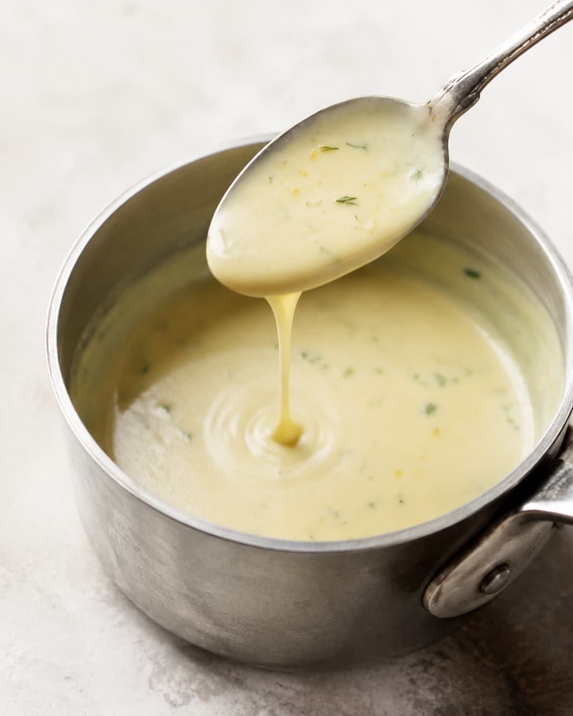 Sauce blanquette falder i en blank sammenhængende stribe fra en ske