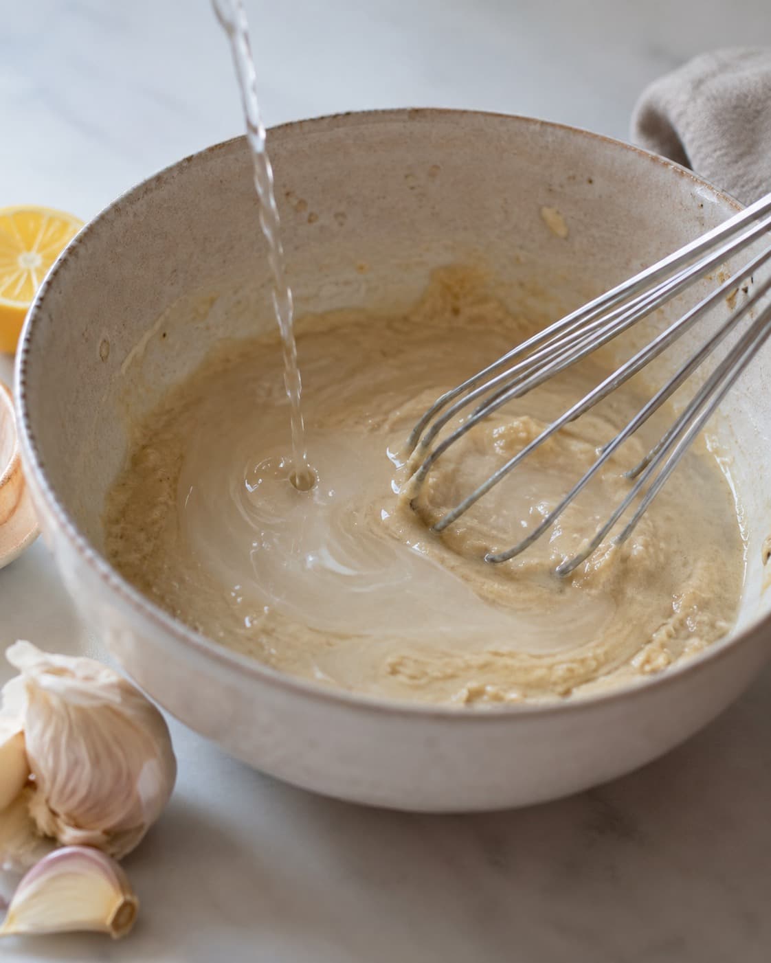 Tahin piskes med citron og iskoldt vand til en lys glat sauce