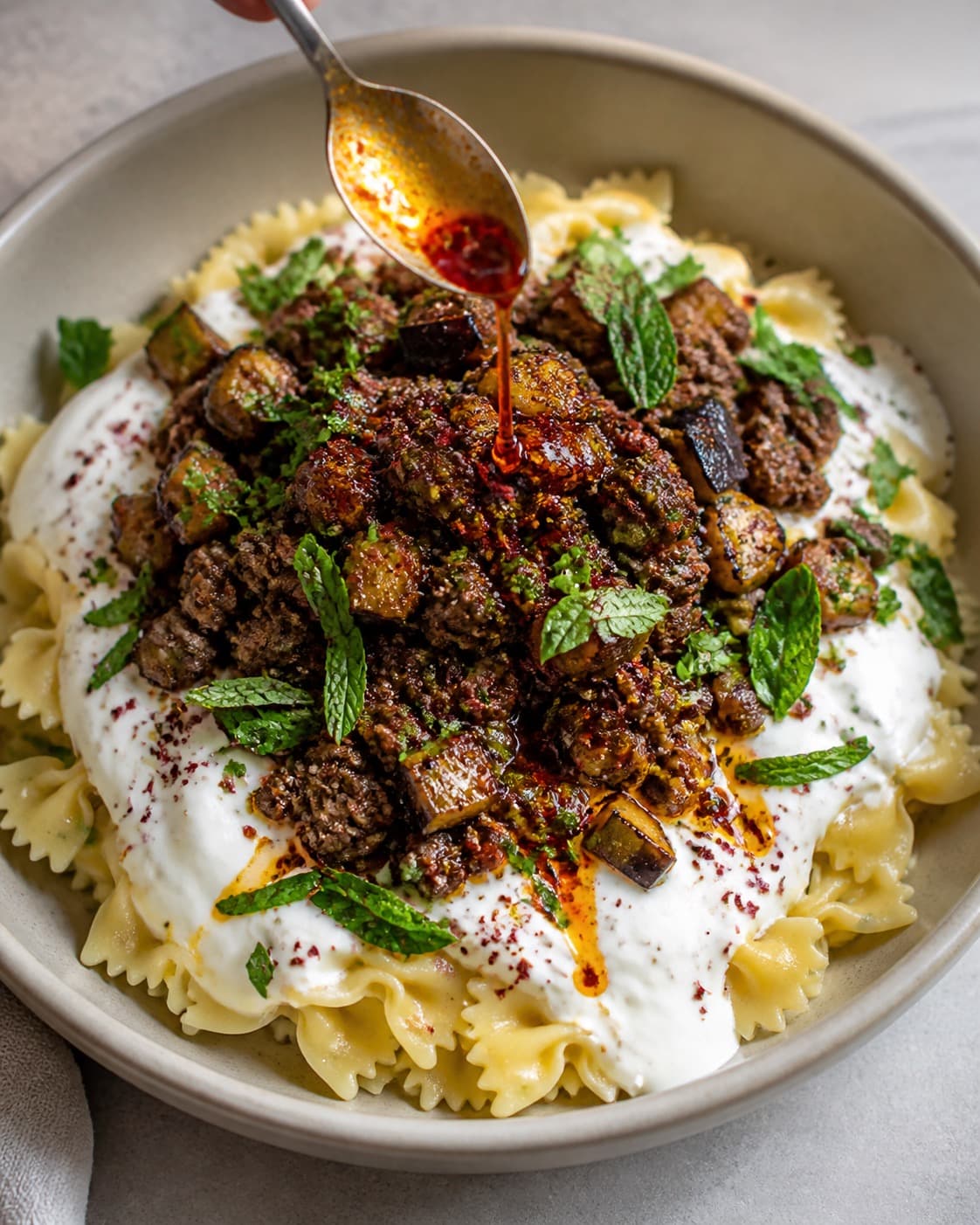 Tyrkisk pasta samles i lag med hvidløgsyoghurt, krydret kød, aubergine og paprikasmør