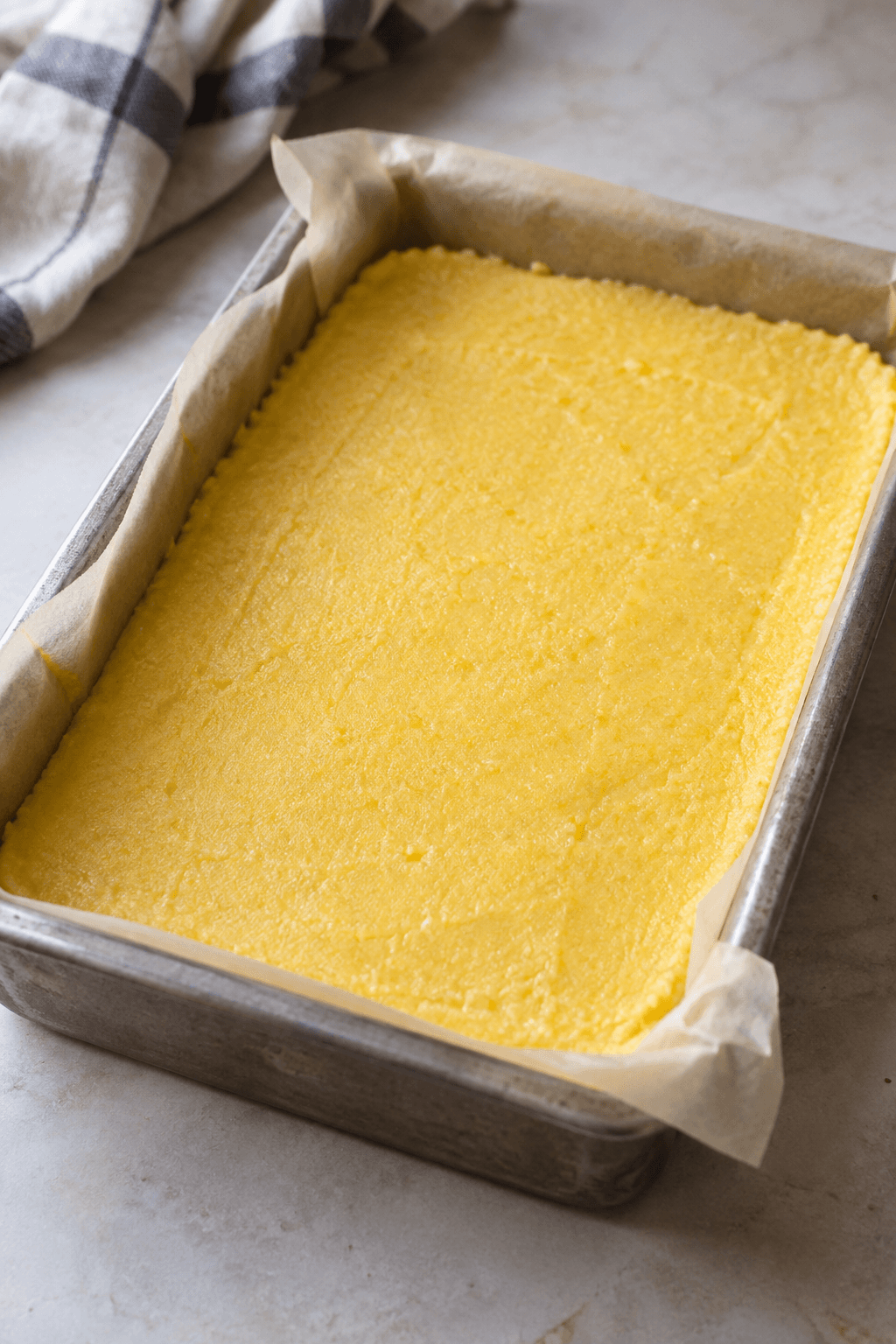 Tyk gul polenta køler i et jævnt lag i en foret form