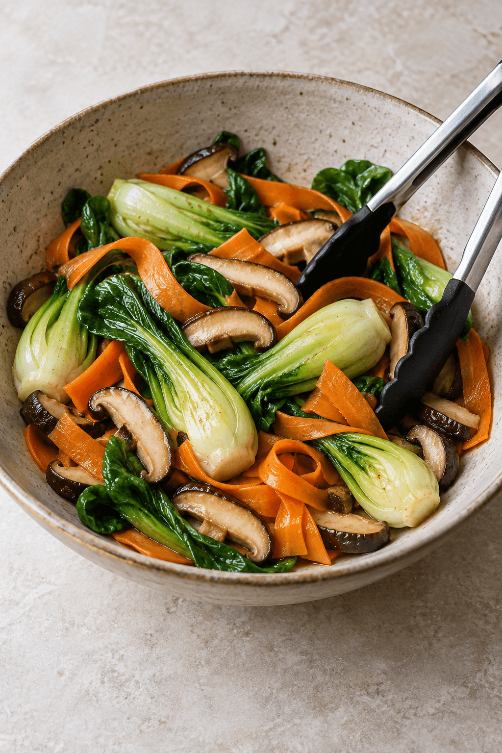 Pak choi, shiitake og gulerodsbånd vendes i én stor skål