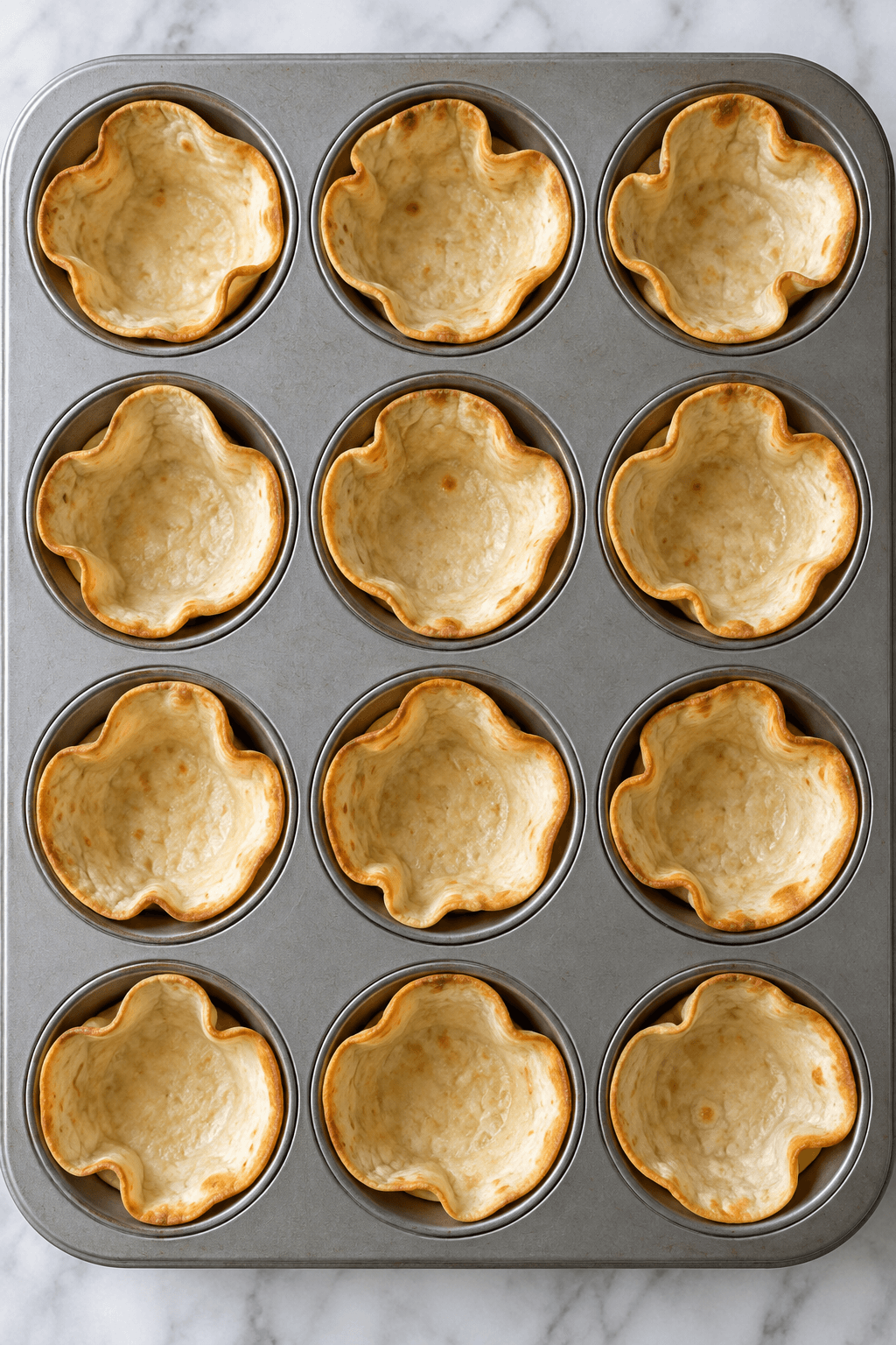 Tolv tortillarundeller presset i en muffinform