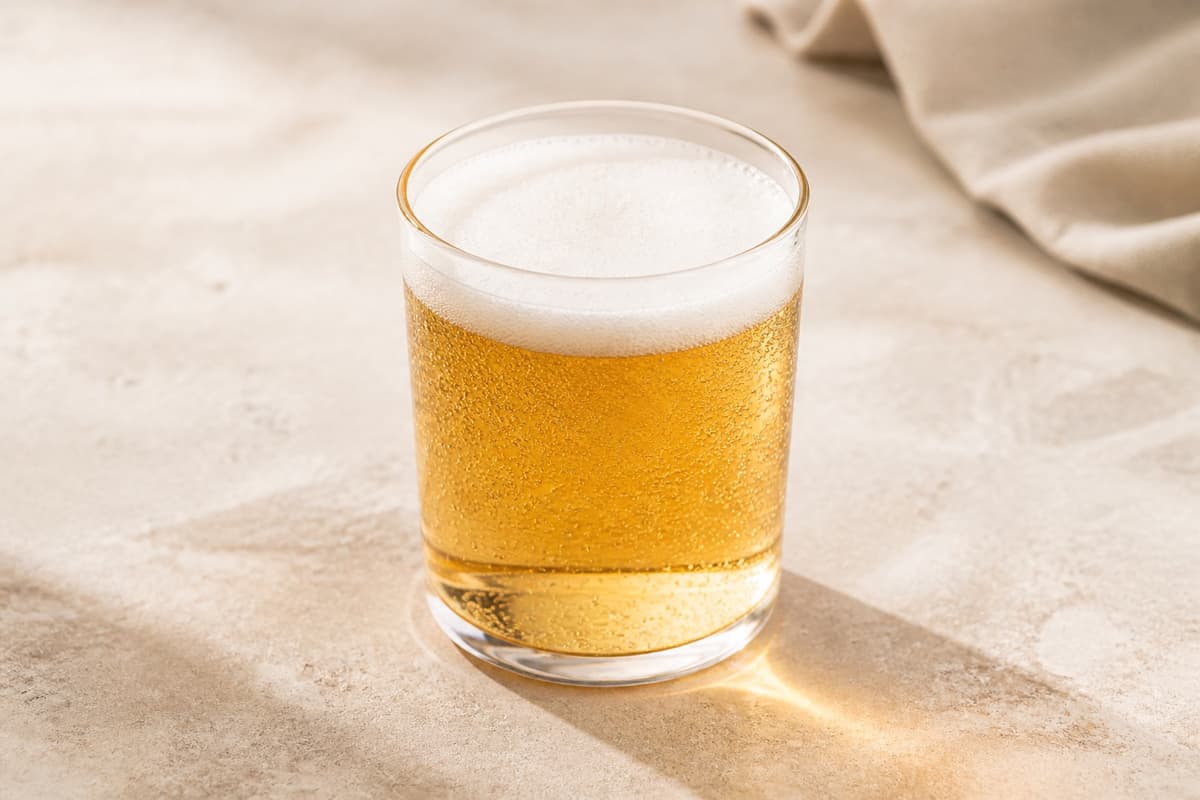 Alkoholfri hvidtøl fotograferet i naturligt nordisk køkkenlys